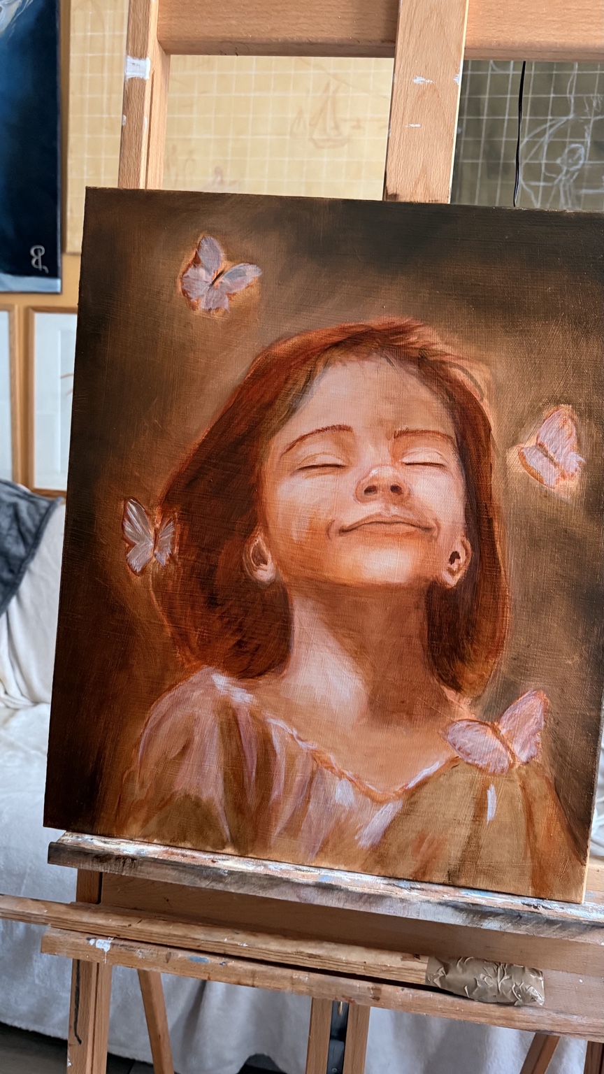 Peinture sur chevalet d’une enfant entourée de papillons